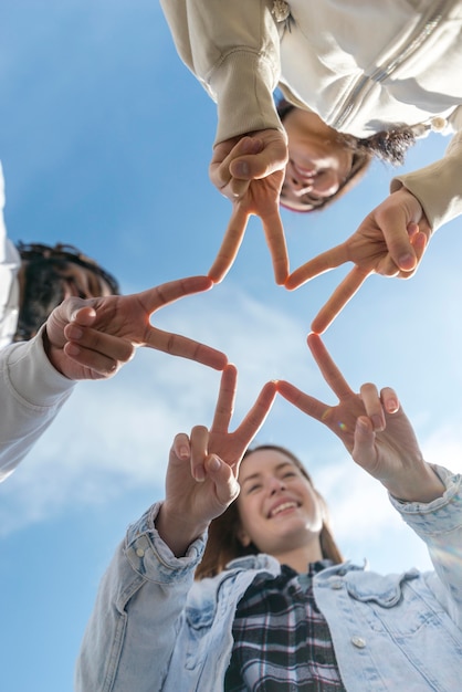 Foto gratuito amigos formando forma de estrella con los dedos