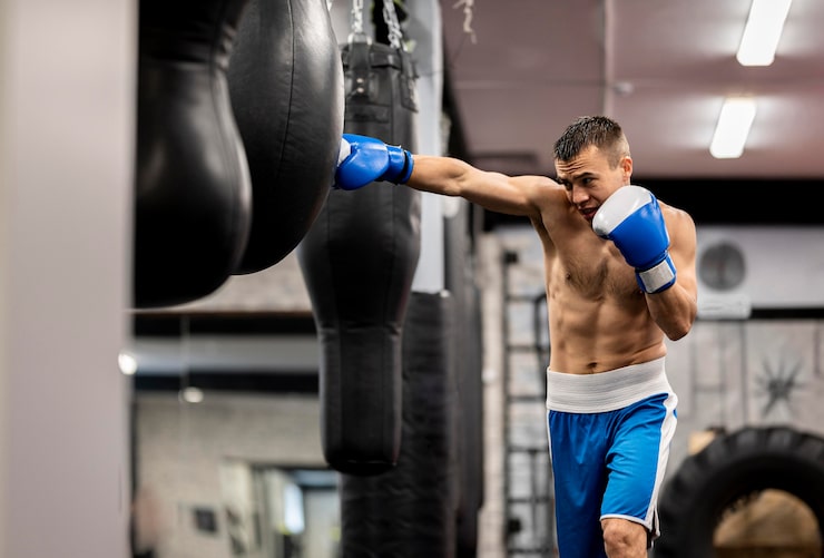 Foto gratuito boxer masculino entrenando con guantes protectores