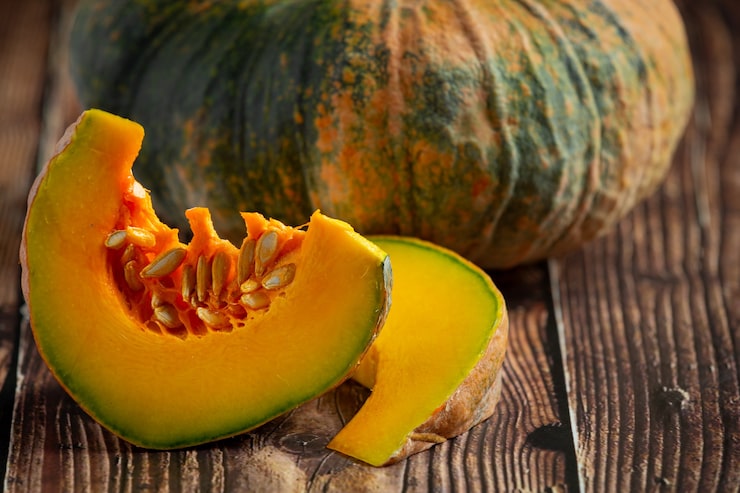 Foto gratuito calabaza cruda picada puesta sobre piso de madera