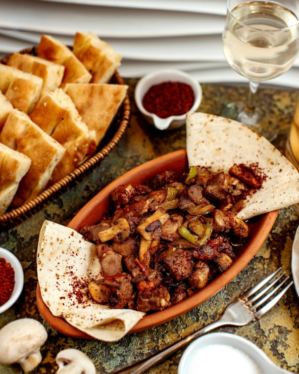 Foto gratuito carne frita con champiñones y canasta con pan