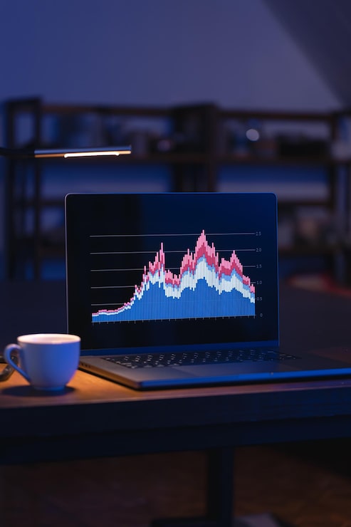 Foto gratuito computadora en una habitación oscura con gráficos en la pantalla