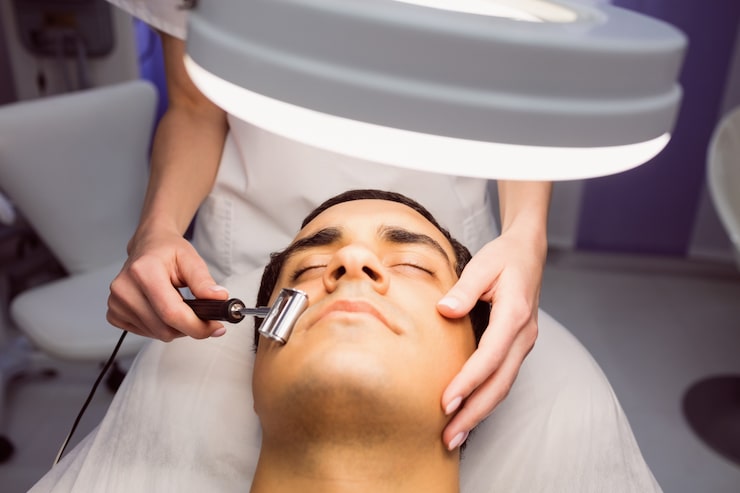 Foto gratuito dermatólogo realizando depilación láser en paciente