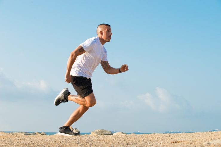 Foto gratuito determinado joven atleta corriendo en la playa