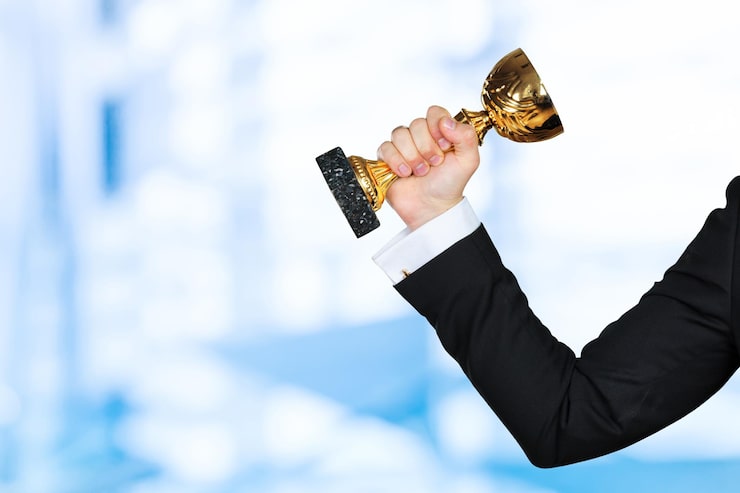 Foto gratuito empresario sosteniendo trofeo de la copa de oro