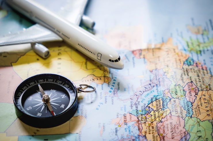 Foto gratuito enfoque selectivo de miniatura turística en la brújula sobre el mapa con avión de juguete de plástico, fondo abstracto para viajar concepto.