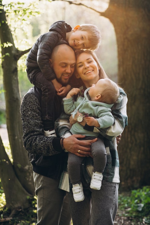 Foto gratuito familia joven con sus hijos divirtiéndose en el bosque.