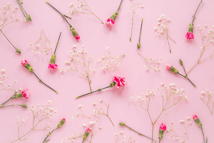 Foto gratuito flores rosas con ramas de plantas en mesa.