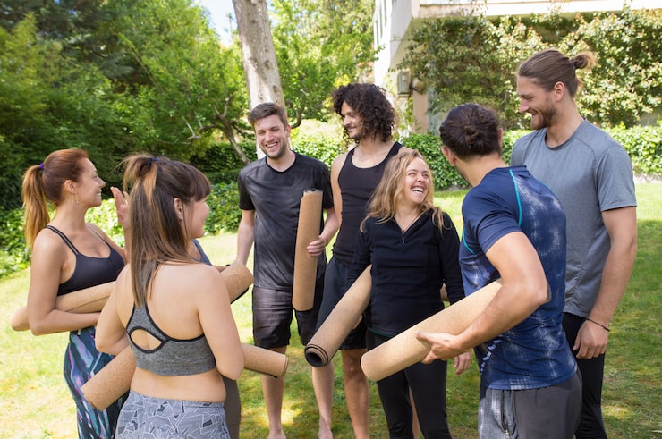 Foto gratuito gente alegre con esteras de yoga charlando y riendo