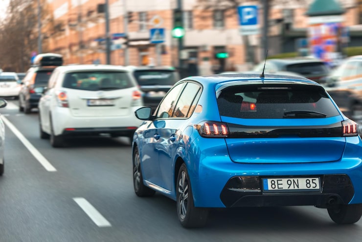 Foto gratuito hatchback azul circulando por una calle de la ciudad, coche moderno en tráfico urbano denso en el centro de la ciudad