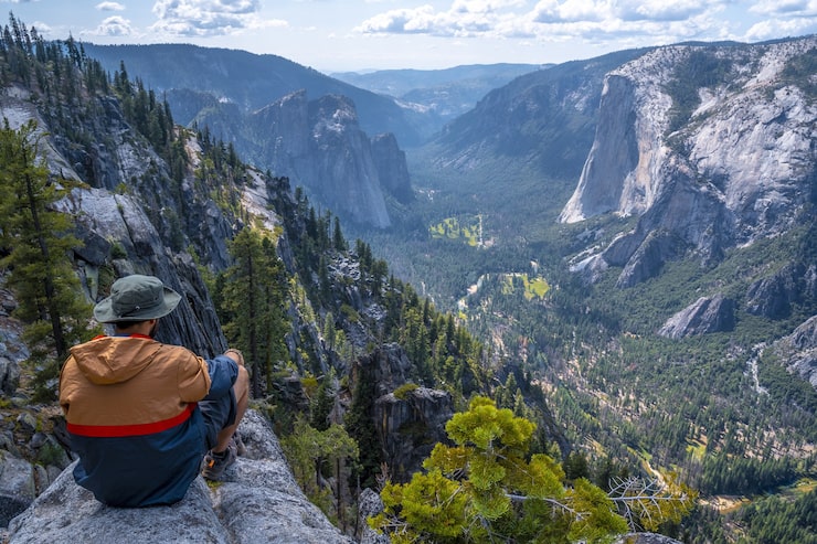 Foto gratuito hombre sentado sobre una roca en el parque nacional de yosemite, sentinel dome yosemite, ee.