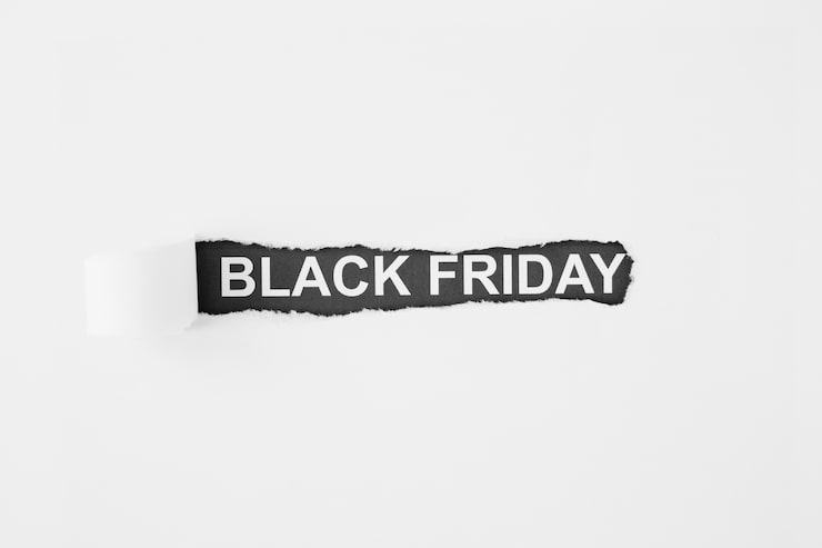 Foto gratuito inscripción viernes negro bajo papel rasgado
