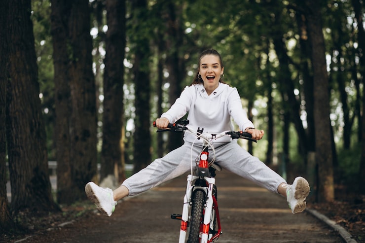 Foto gratuito joven deportiva montando bicicleta en el parque
