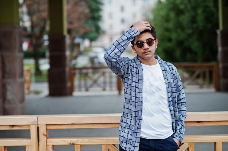 Foto gratuito un joven indio elegante con gafas de sol usa una pose informal al aire libre