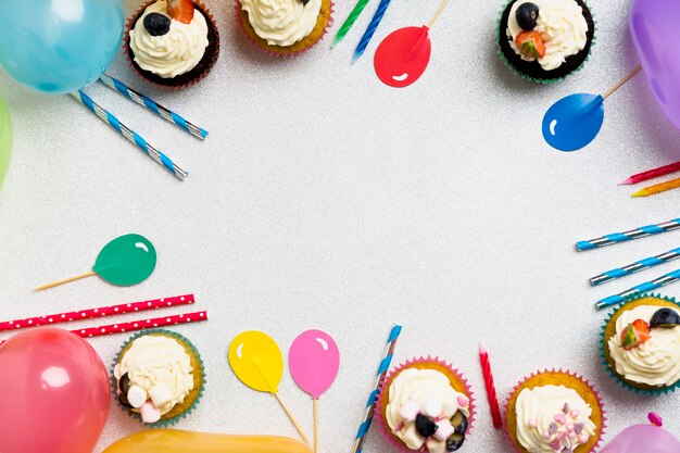 Foto gratuito magdalenas con globos y velas en la mesa
