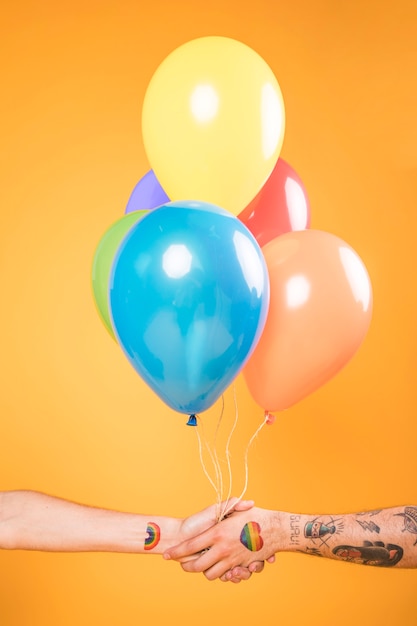 Foto gratuito manos con globos de colores
