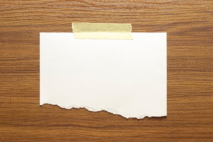 Foto gratuito marco de papel rasgado en blanco pegado con cinta adhesiva a la pared con textura de madera
