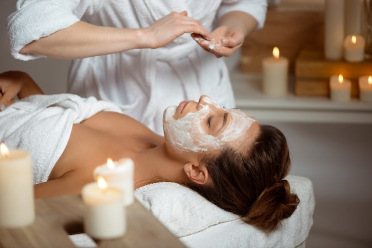 Foto gratuito mujer joven en la máscara para la cara relajante en el salón de spa.