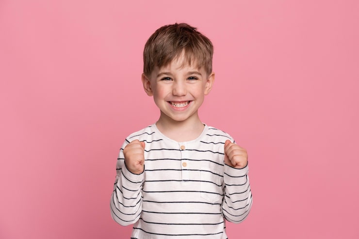Foto gratuito niño sonriente aislado en rosa