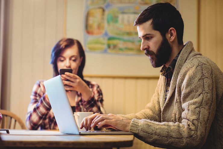Foto gratuito pareja usando laptop y teléfono móvil