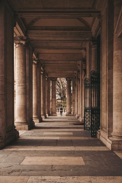 Foto gratuito persona caminando por un edificio de hormigón marrón