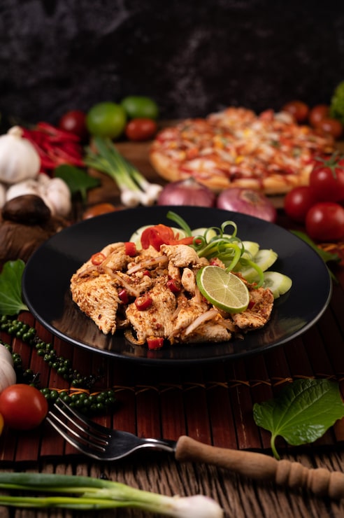 Foto gratuito pollo larb al plato con chiles secos, tomates, cebolletas y lechuga