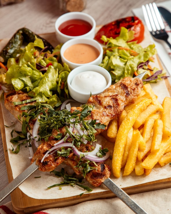 Foto gratuito pollo lula papas fritas ensalada vista lateral