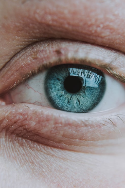 Foto gratuito primer plano vertical del ojo azul claro de un ser humano anciano
