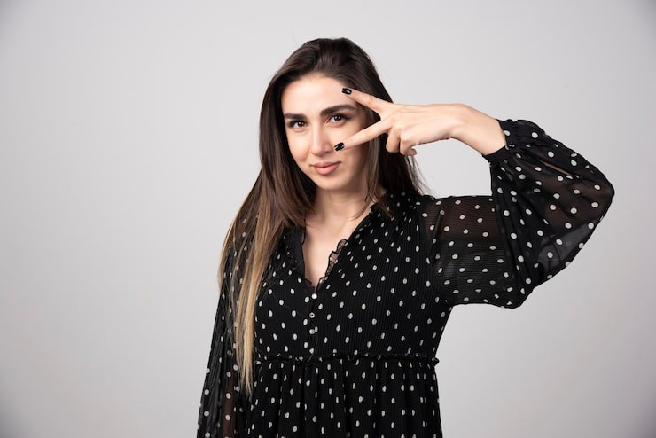Foto gratuito retrato de mujer de pie sobre gris.