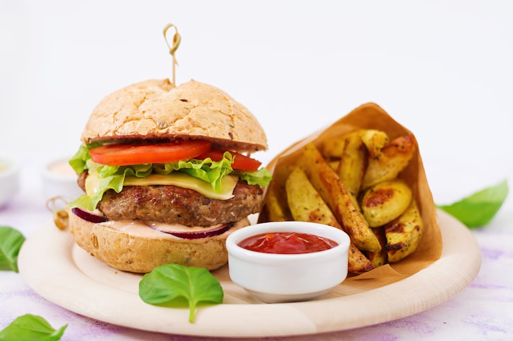 Photo Gratis sandwich besar - hamburger dengan burger daging sapi juicy, keju, tomat, dan bawang merah serta kentang goreng.
