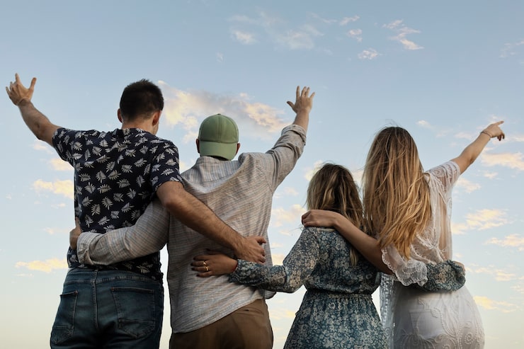 Photo Gratis teman-teman berpelukan di pantai melihat ke langit