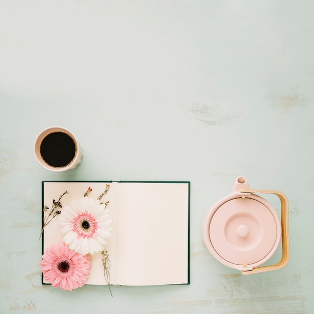 Foto gratuito tetera y bebida cerca de notebook con flores