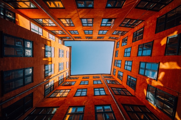 Foto gratuito tiro de ángulo bajo de un edificio naranja de gran altura único tocando el cielo