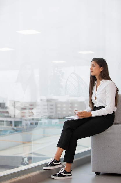 Foto gratuito tiro completo mujer sentada en una silla