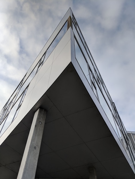 Foto gratuito tiro vertical de ángulo bajo de un edificio triangular de gran altura