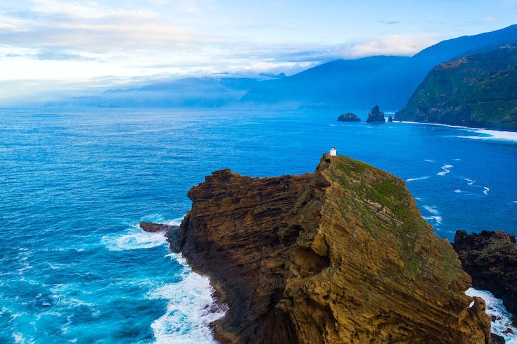 Foto gratuito toma aérea de olas del mar rompiendo en formaciones de piedra