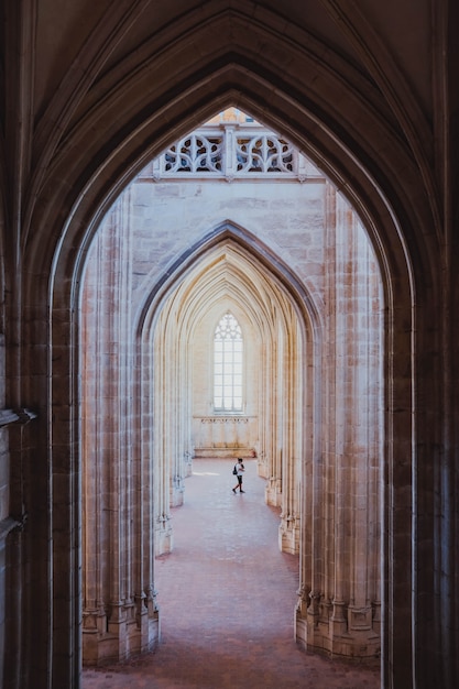 Foto gratuito tomada vertical de los pasillos en forma de arco en un edificio antiguo