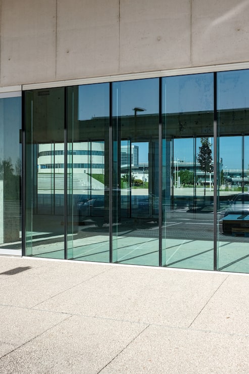 Foto gratuito tomada vertical de las puertas transparentes de un edificio comercial