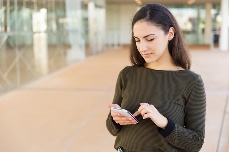 Foto gratuito usuario de telefonía celular serio enfocado que consulta internet