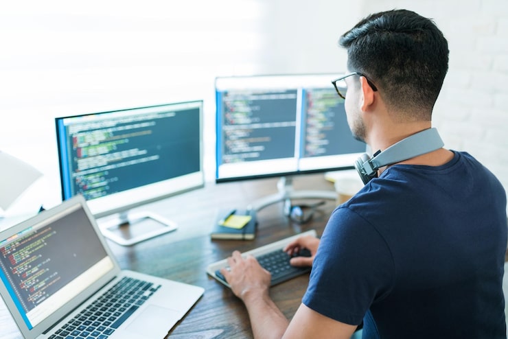 Foto gratuito vista trasera de la programación de un joven desarrollador de software latino mientras trabaja desde casa