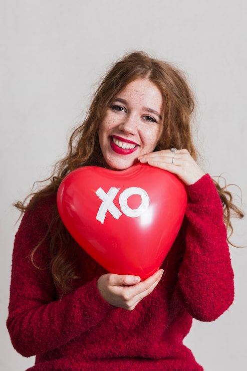 Photo Gratis wanita cantik berpose dengan balon berbentuk hati
