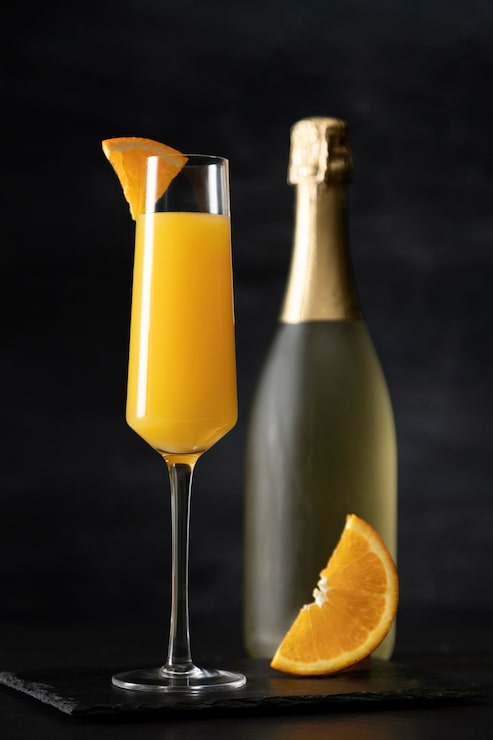 Foto gratuito cocktail mimosa con sfondo scuro