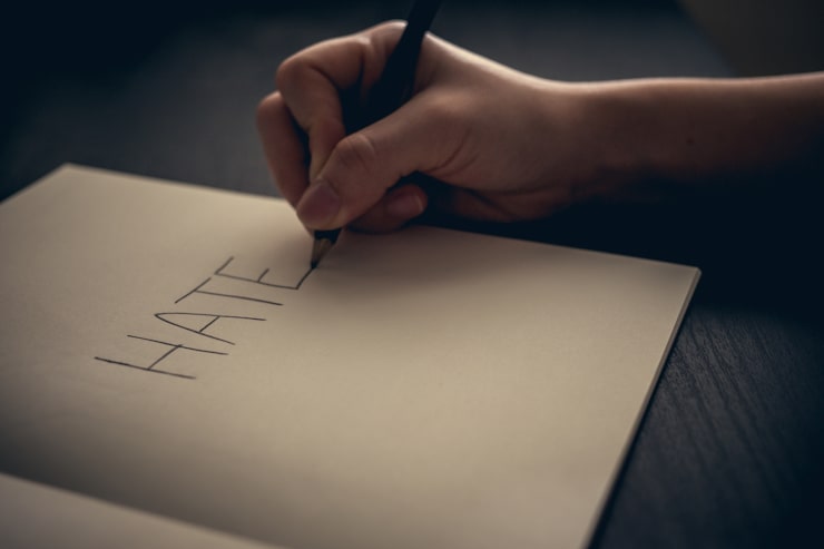Foto gratuito concetto di odio - mano che scrive odio sul libro