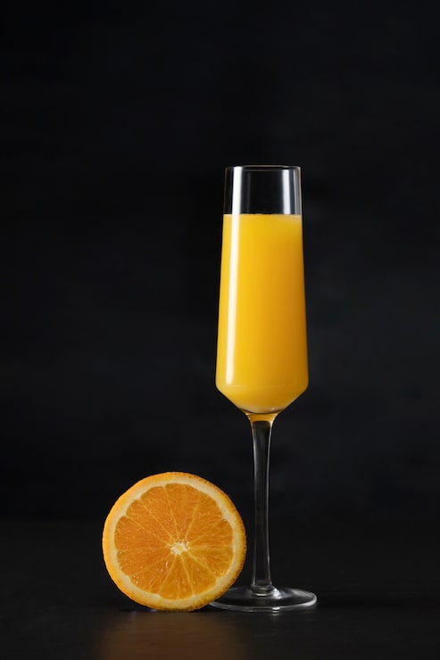 Foto gratuito delizioso cocktail di mimosa e fetta d'arancia