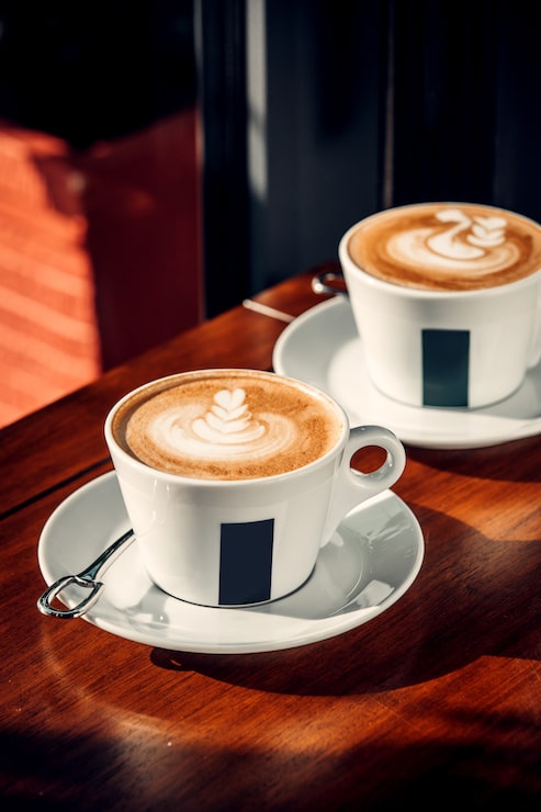 Foto gratuito due tazze di caffè con latte art.