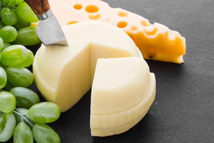 Foto gratuito formaggio ad alto angolo con coltello