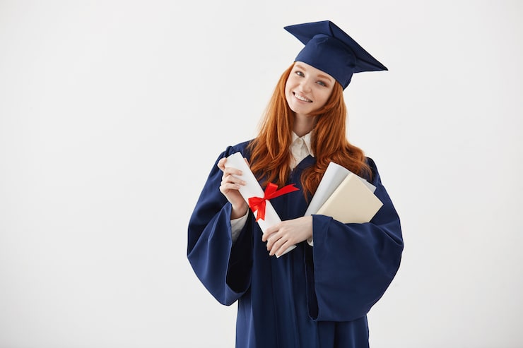 Foto gratuito libri e diploma sorridenti della tenuta del bello laureato femminile della testarossa.