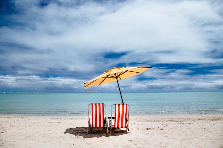 Foto gratuito ombrellone da spiaggia e sedie da spiaggia rosse su una riva
