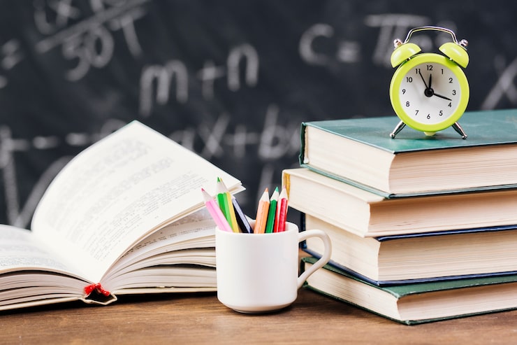 Foto gratuito orologio in cima ai libri di testo alla cattedra