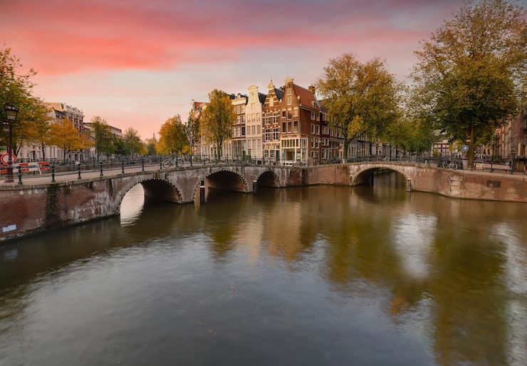 Foto gratuito scenario del canale keizersgracht ad amsterdam con la riflessione di edifici e alberi verdi