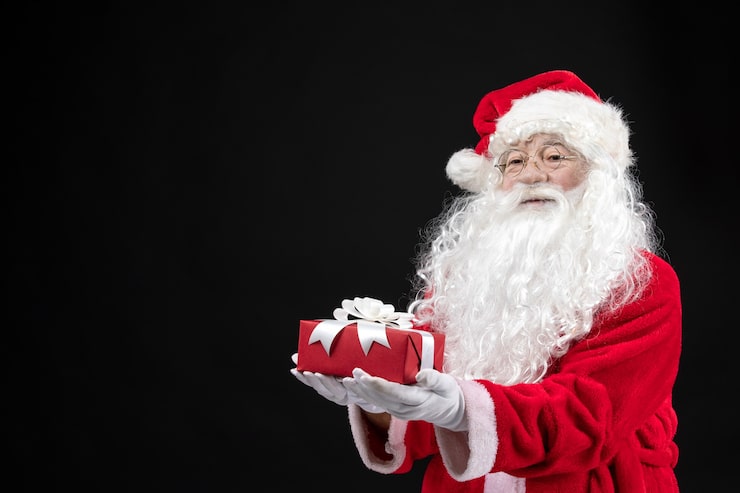 Foto gratuito vista frontale babbo natale in abito rosso classico che tiene presente